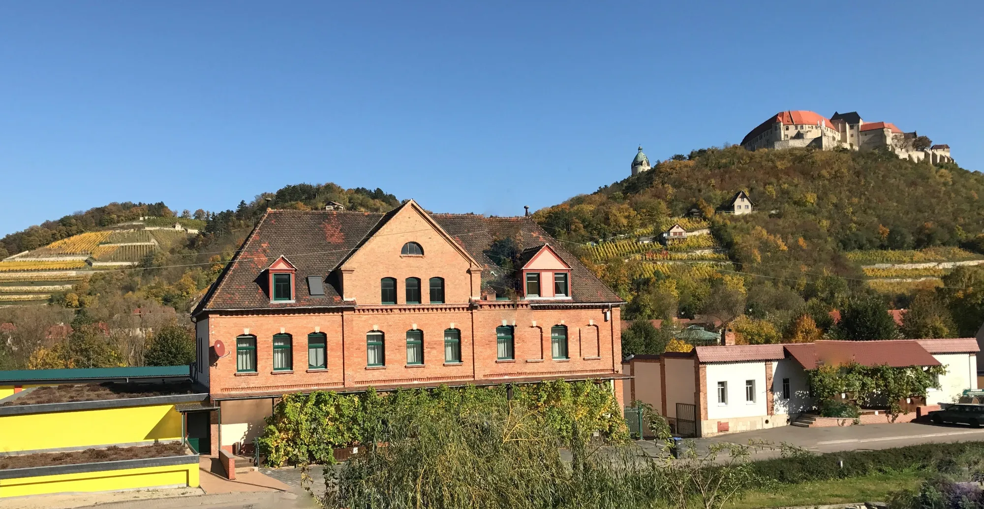 Pension Unstrutpromenade in Freyburg mit Schloss Neuenburg und Weinbergen im Hintergrund